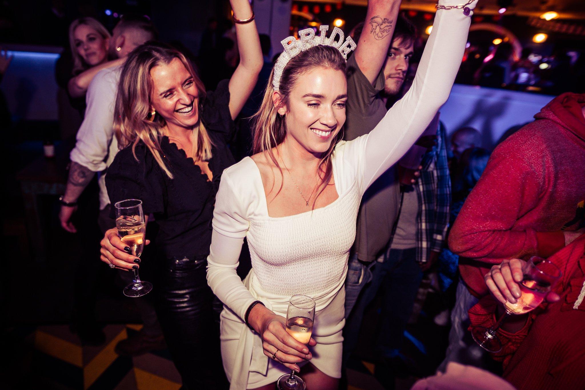 A woman dressed in white with a Bride headband on celebrating her hen party in The Piano Works