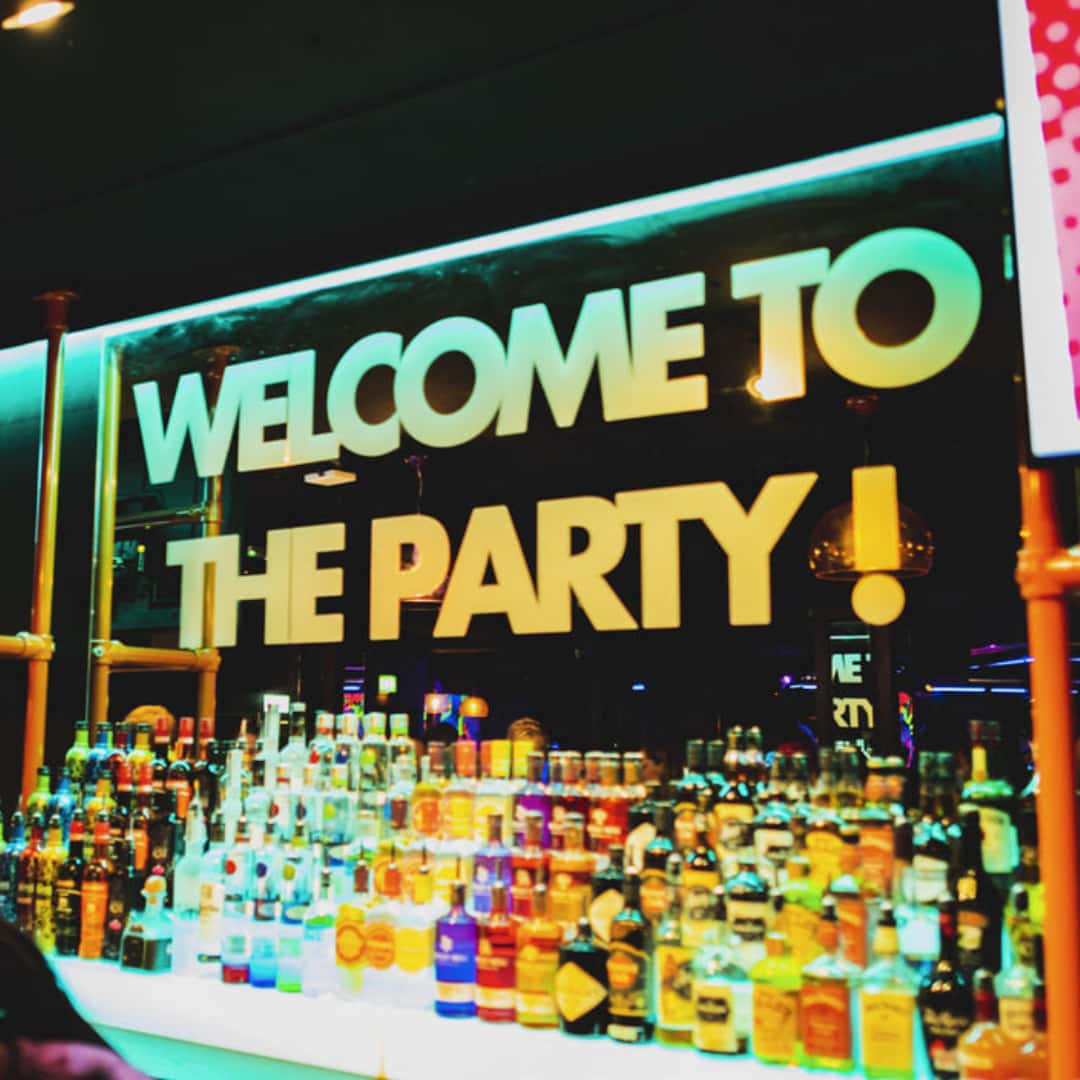 Welcome to the party sign behind bar