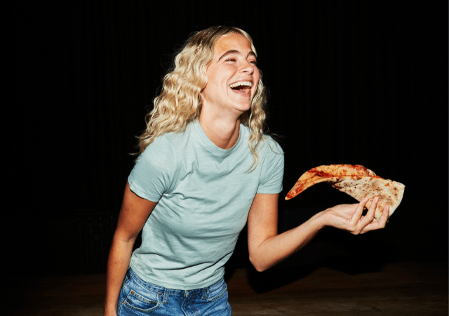 Person smiling at Rita's XXL pizza slice