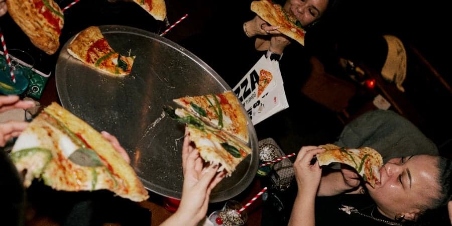 People enjoying Rita's pizza slices