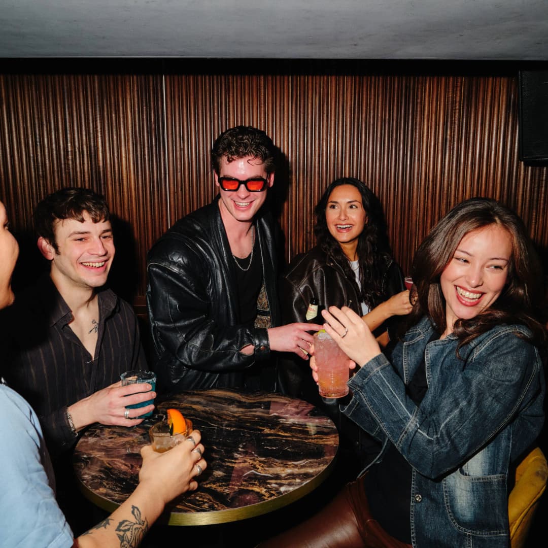 People drinking cocktails at Be At One