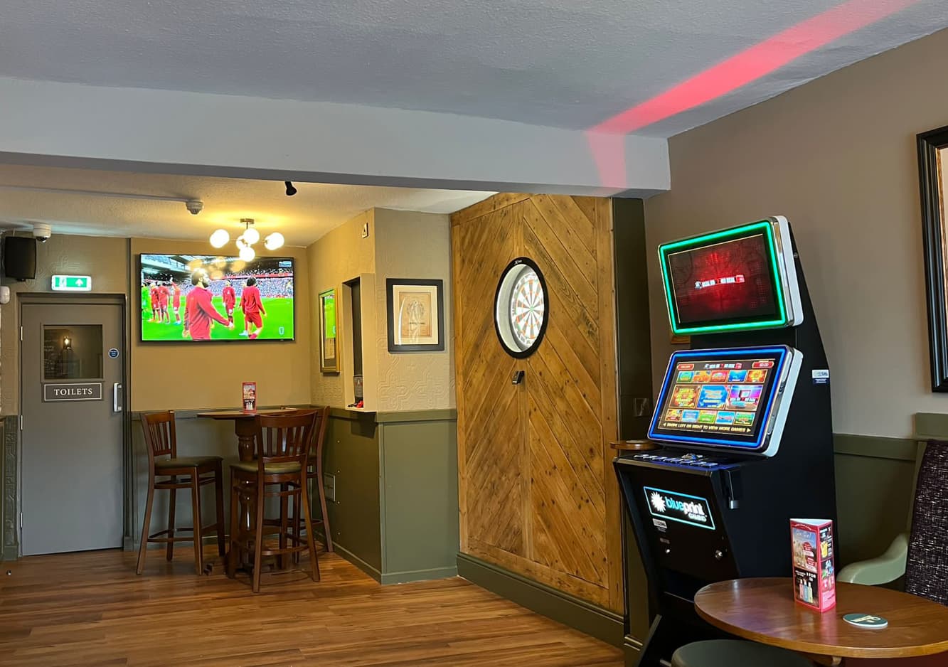 the dart board and games machine in the pub