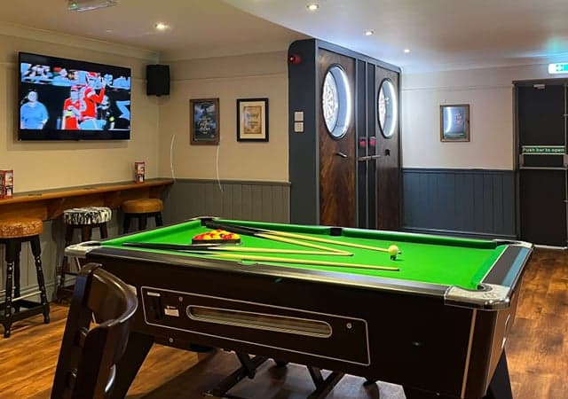 Pool table and dart boards inside the pub