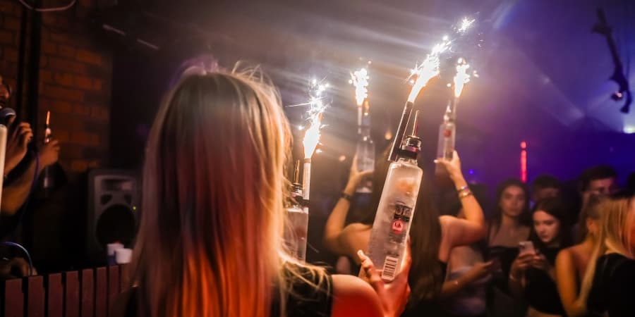 Bottles with sparklers being carried through crowd