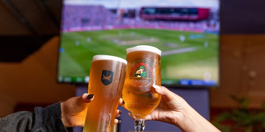 Pint cheers in front of TV screen