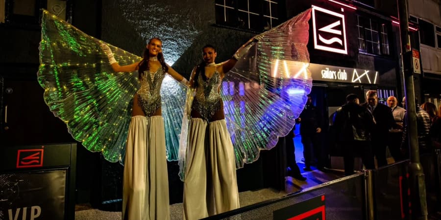 Two girls on stilts outside nightclub