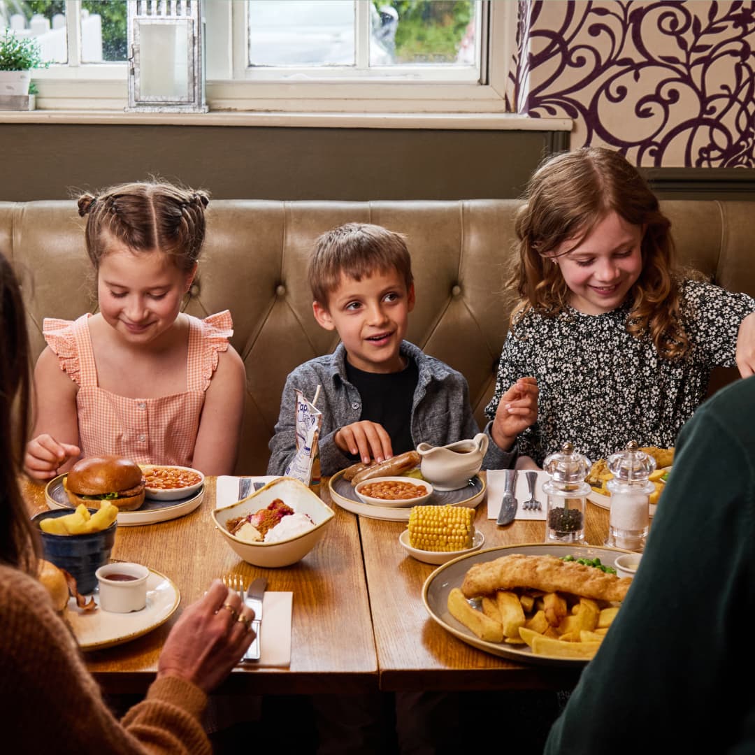 Three Children Eating at a dining table
