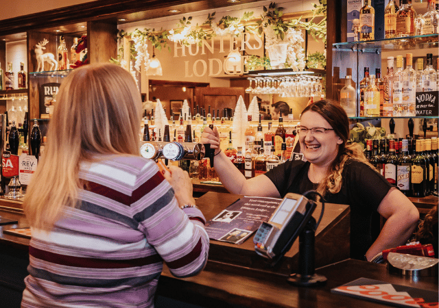 Bar tender and customer laughing