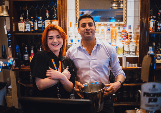 Two bar tenders smiling