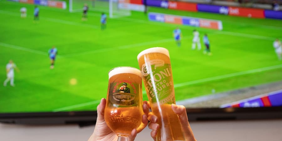 Cheers in front of a TV screen