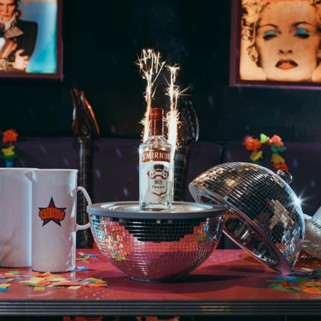 Bottle of vodka served in a disco ball with sparklers
