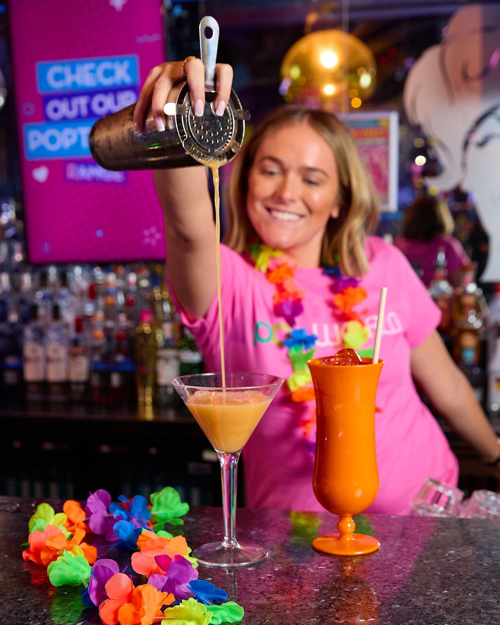 Popworld team member pouring a cocktail