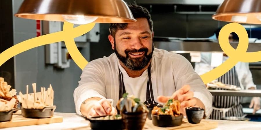 Man dressed in chef uniform plating up food