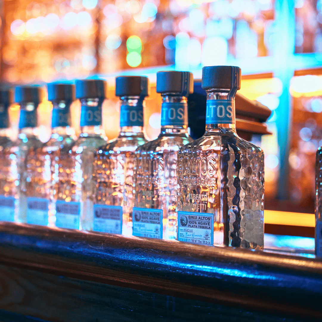 Bottles of Altos tequila lined up on the bar