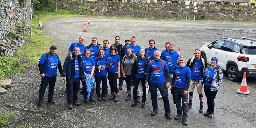 Image of Stonegate colleagues smiling as they embark on a walk in blue MNDA tops.