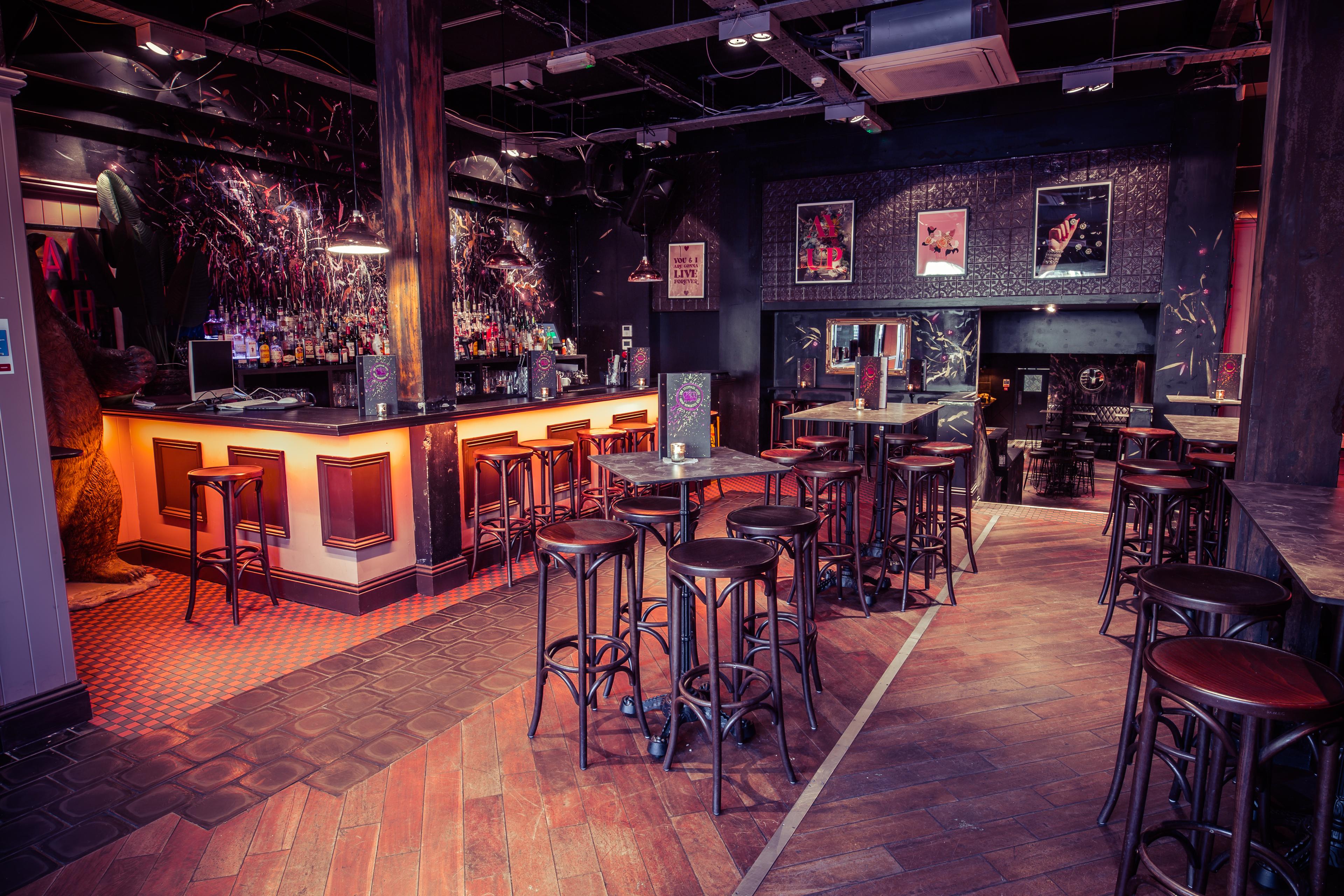 A bar area with stool seating and dark walls