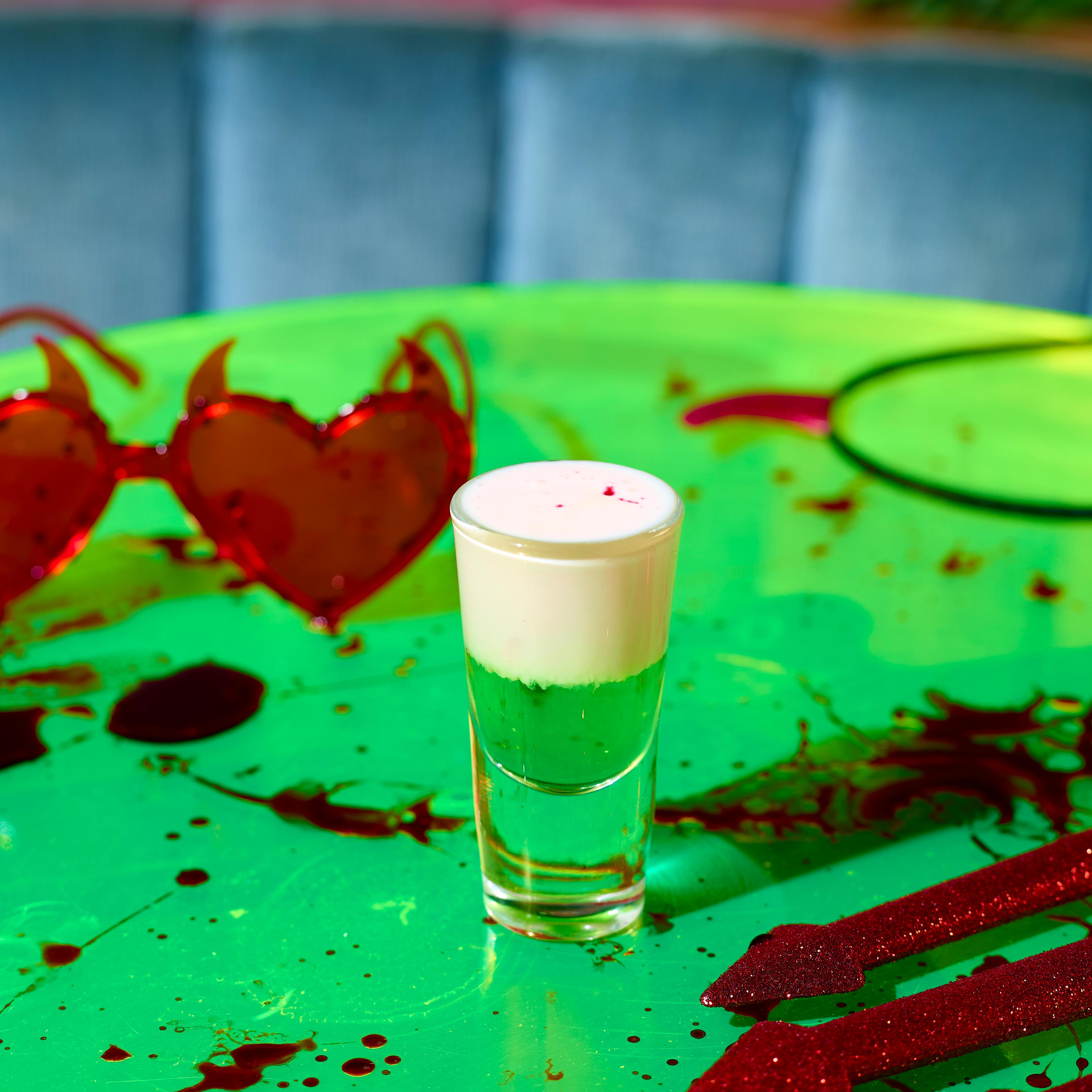 Image of a green and white Halloween shot on a table at Nikki's Bar