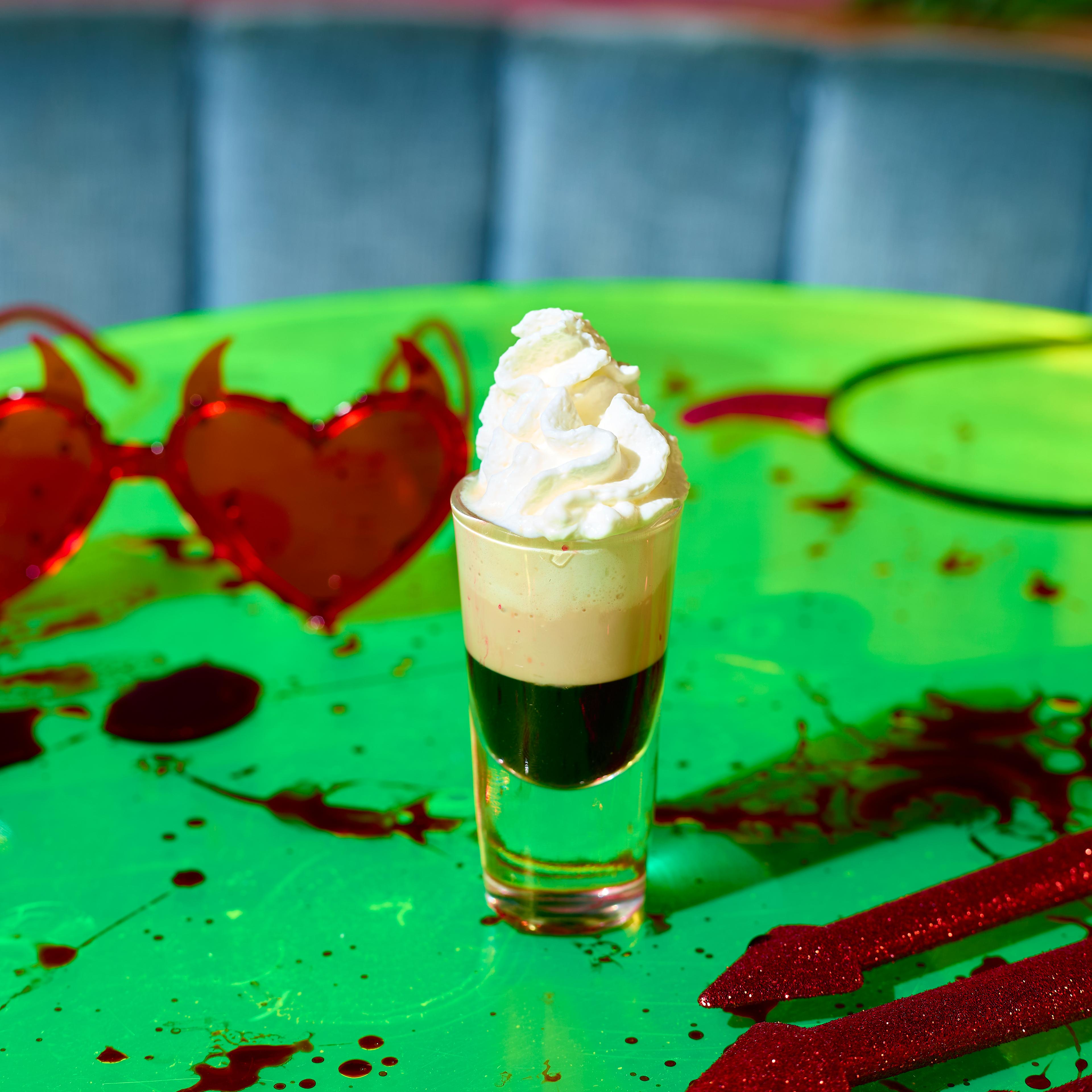 Image of a layered Halloween shot with whipped cream on top at Nikki's Bar