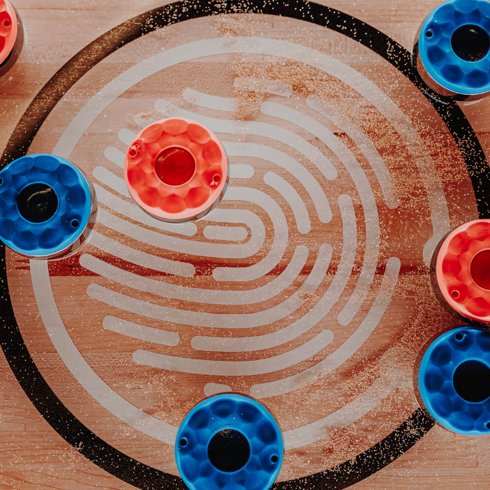 Pucks on the Shuffleboard table at PLAYBOX in Croydon