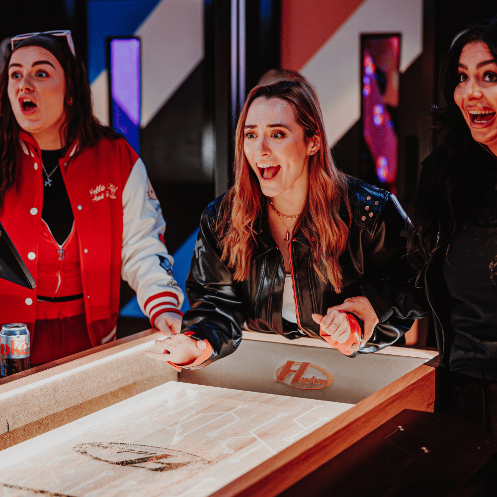 Customers playing Shuffleboard at PLAYBOX in Croydon
