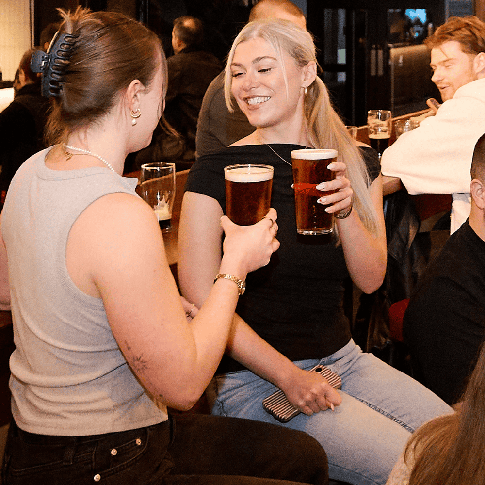 Two guests drinking pints of Pravha at Boxhall in Liverpool Street