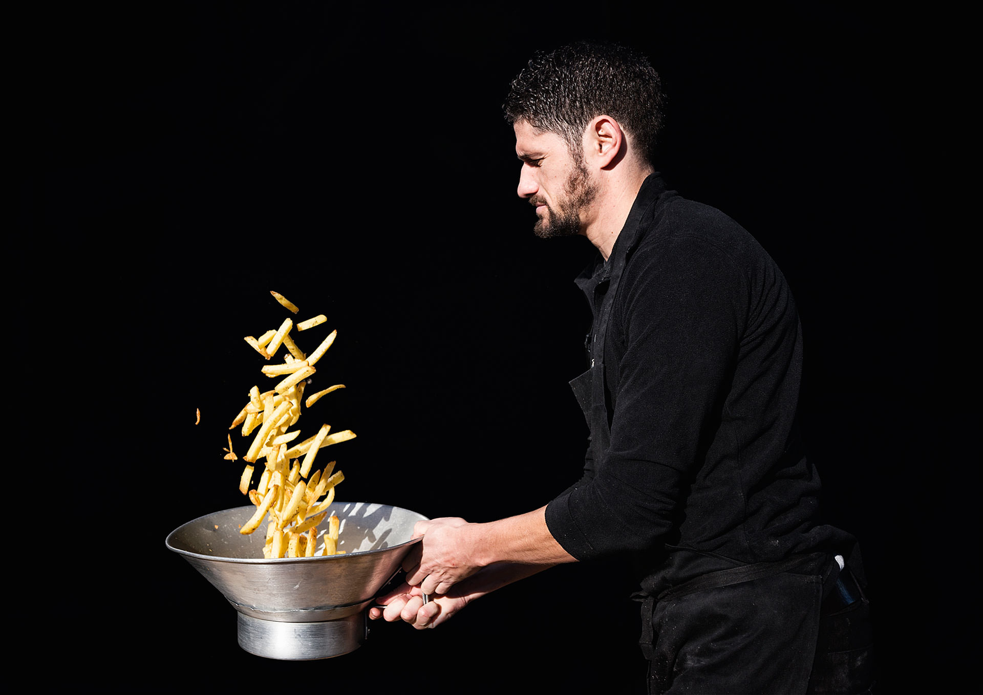 A chef tossing fries at Poptata in Boxpark Camden
