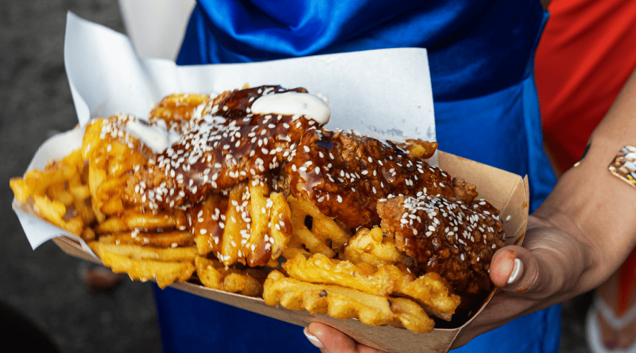 A guest eating Street Food at the BOXPARK Festival Zone at Aintree