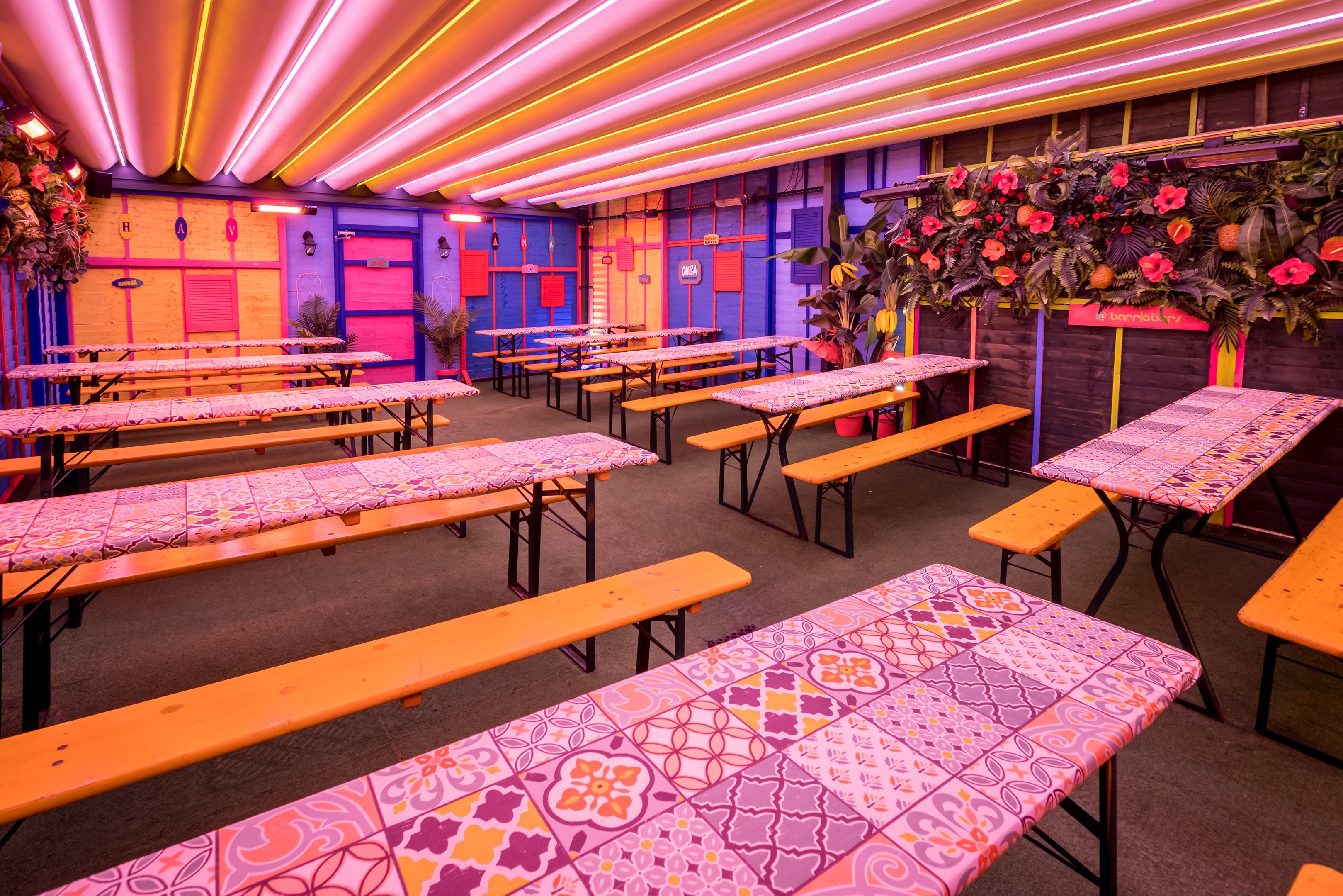 Bench seating with a neon light ceiling at Barrio Shoreditch