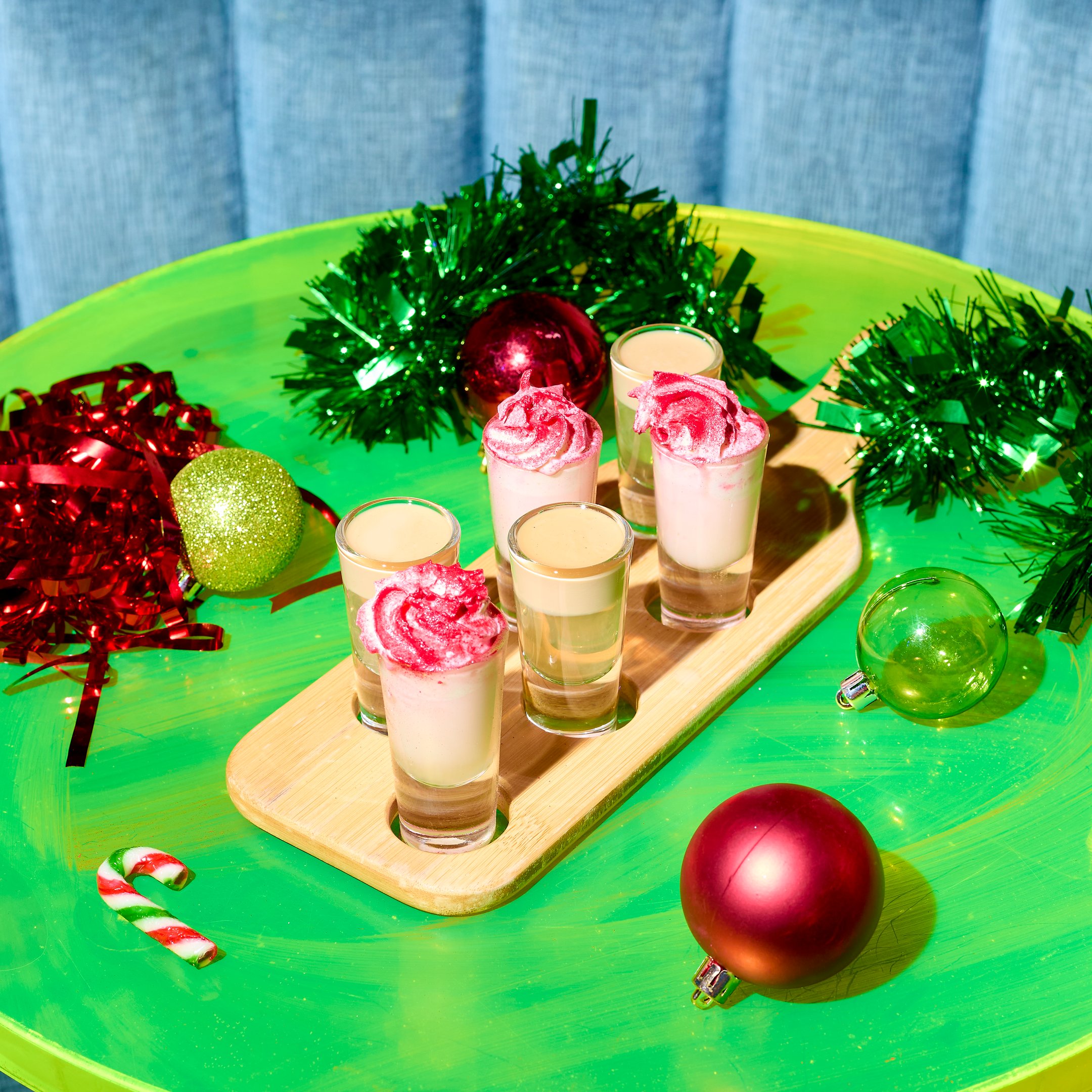 A shot paddle with six Christmas shots on a festive table