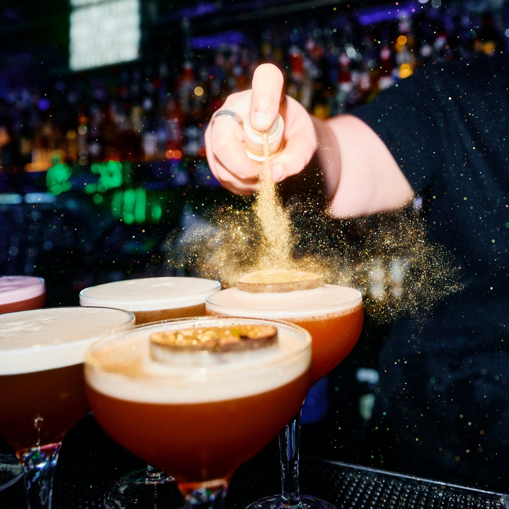 Spraying Lustre edible glitter onto porn star martini cocktails in Tonight Josephine
