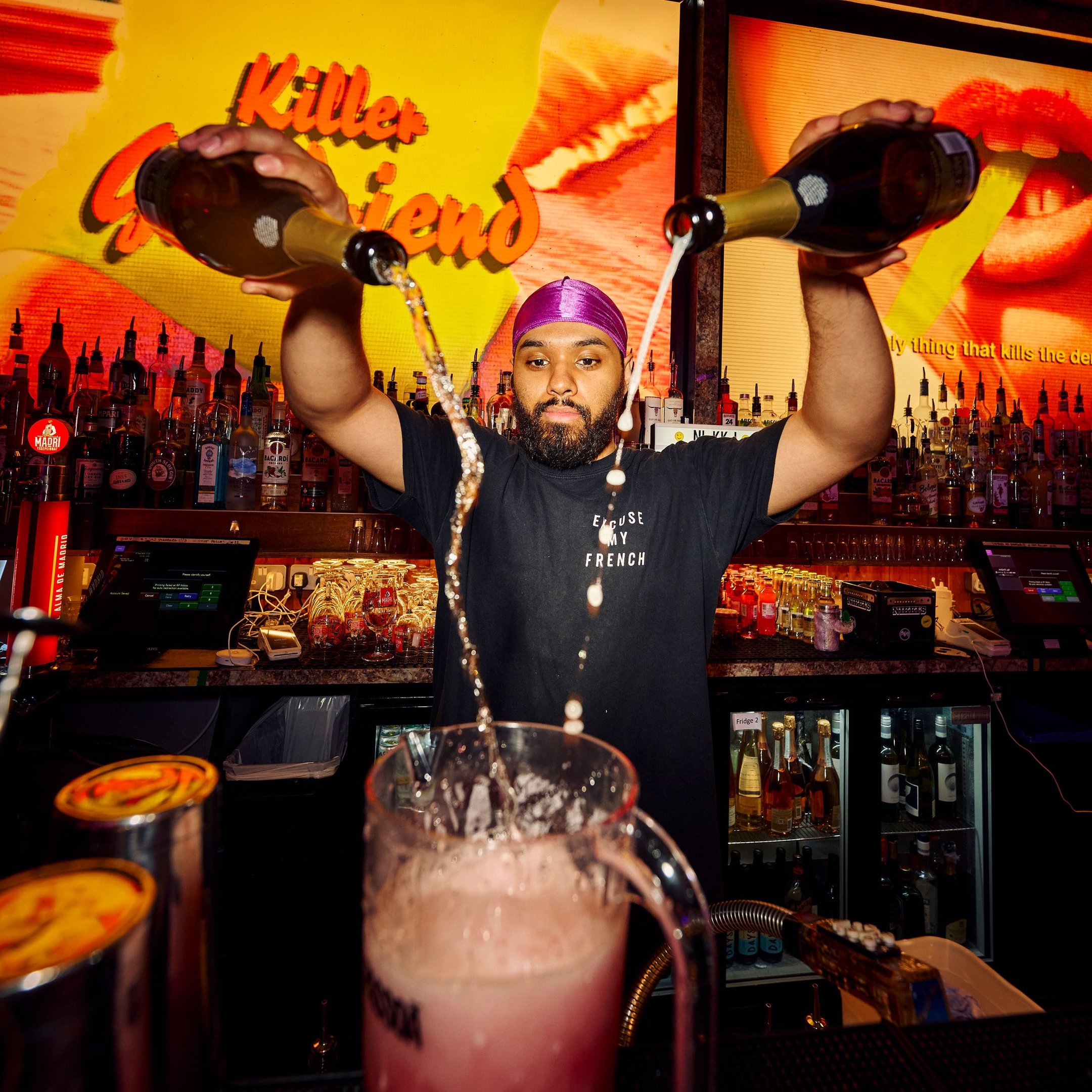 Bartender in Nikki's pouring prosecco into a cocktail jug