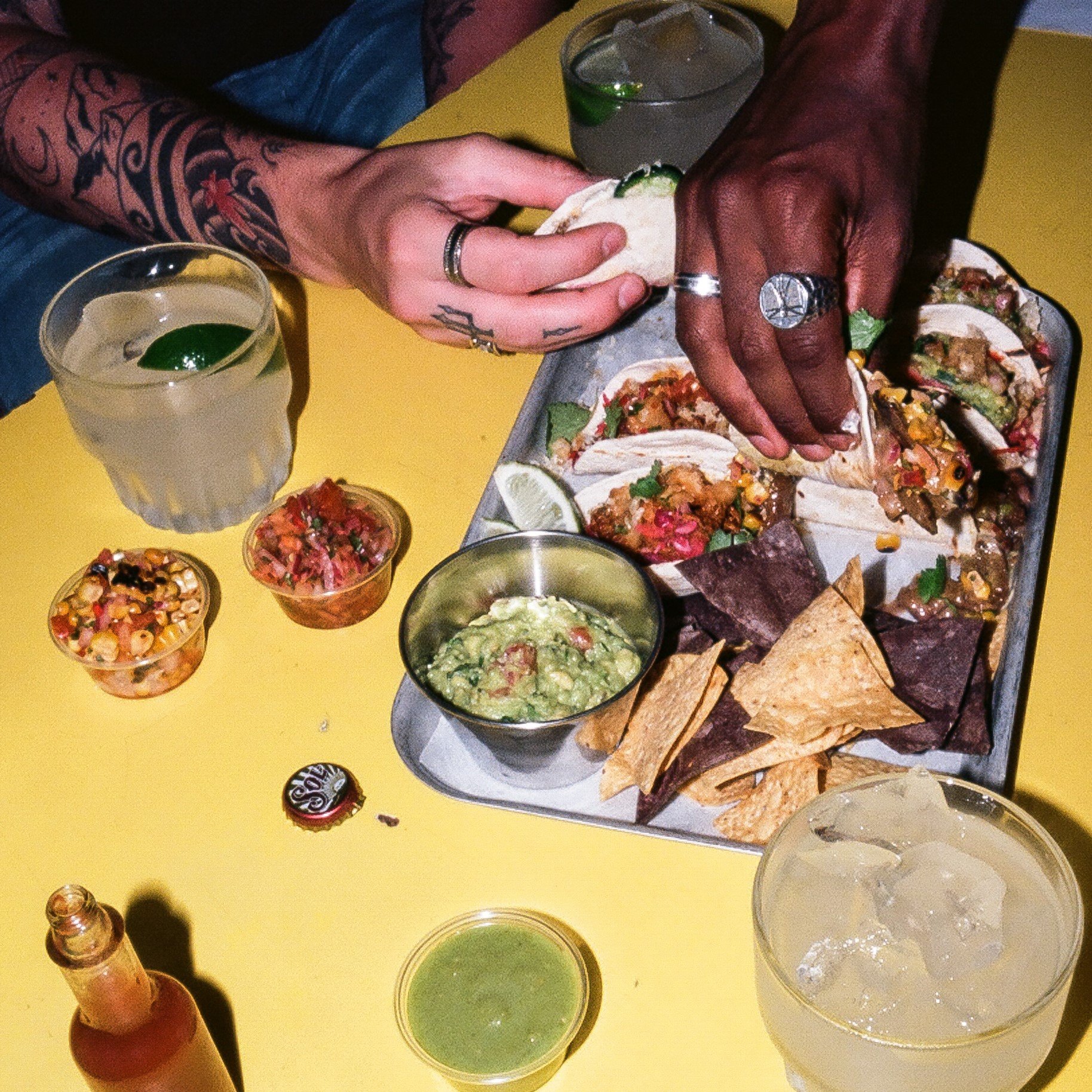 A platter of Tacos and Tommy's Margaritas on a table in Barrio