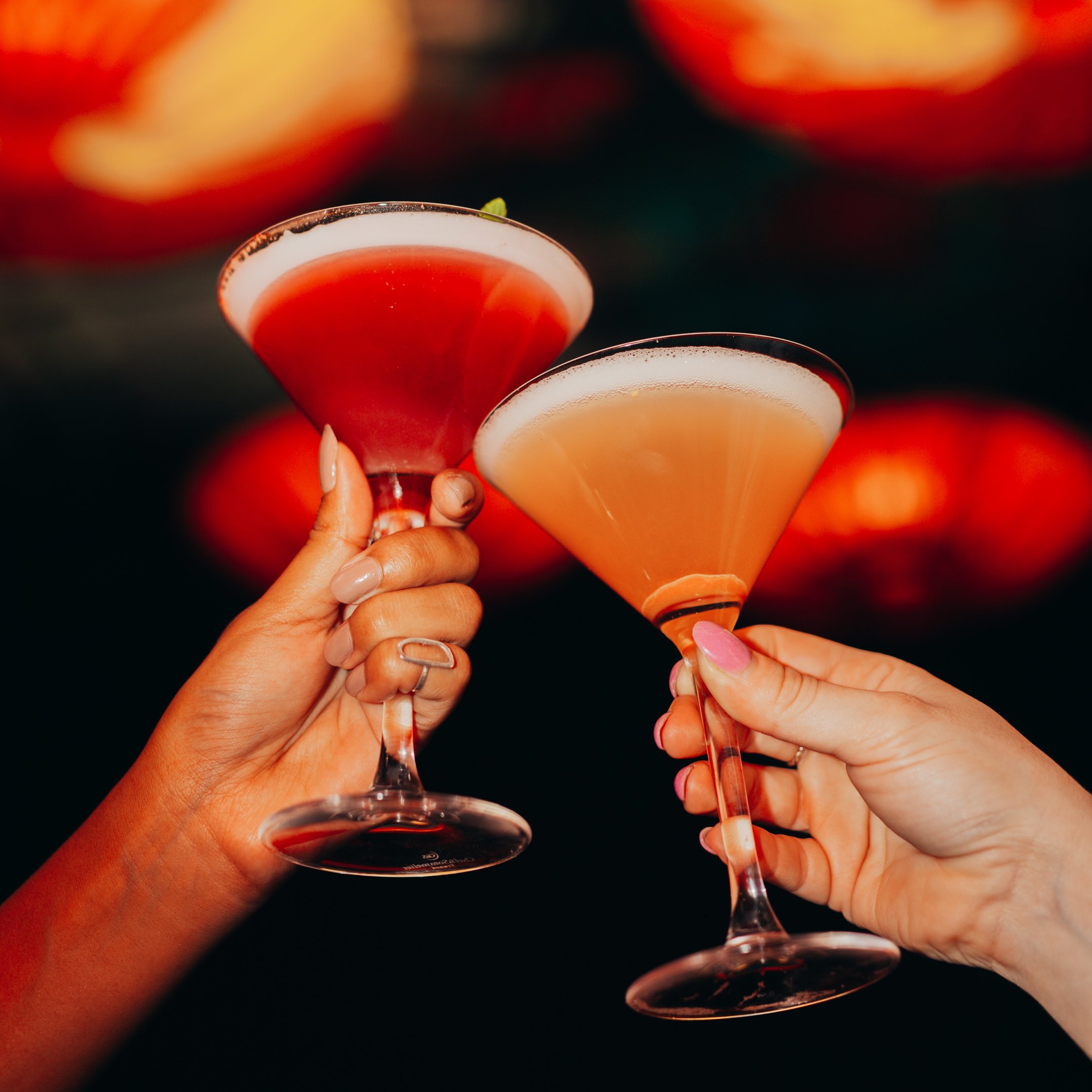 Two Martini glasses being held by customers in Dirty Martini