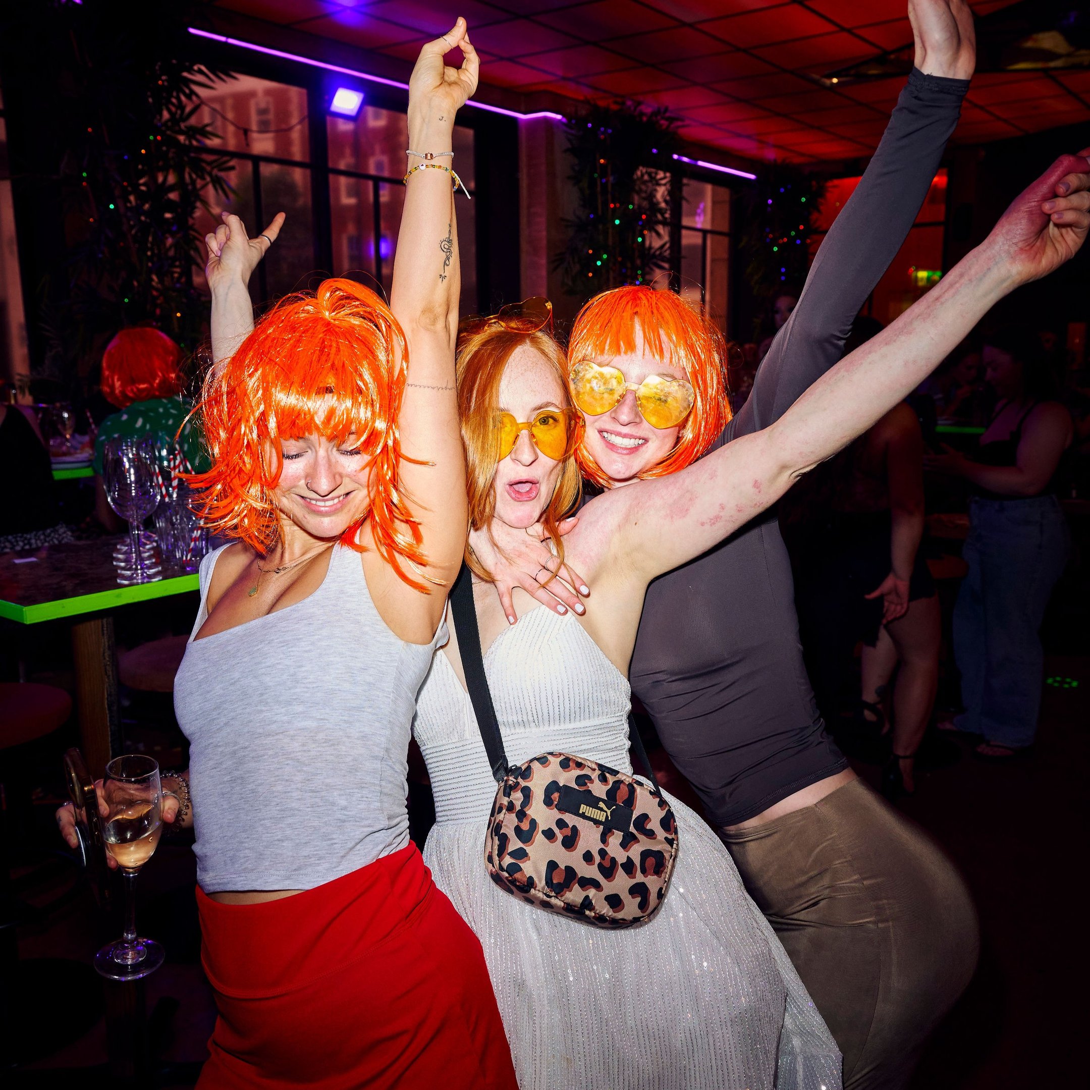 Guests wearing wigs and dancing in Nikki's bar