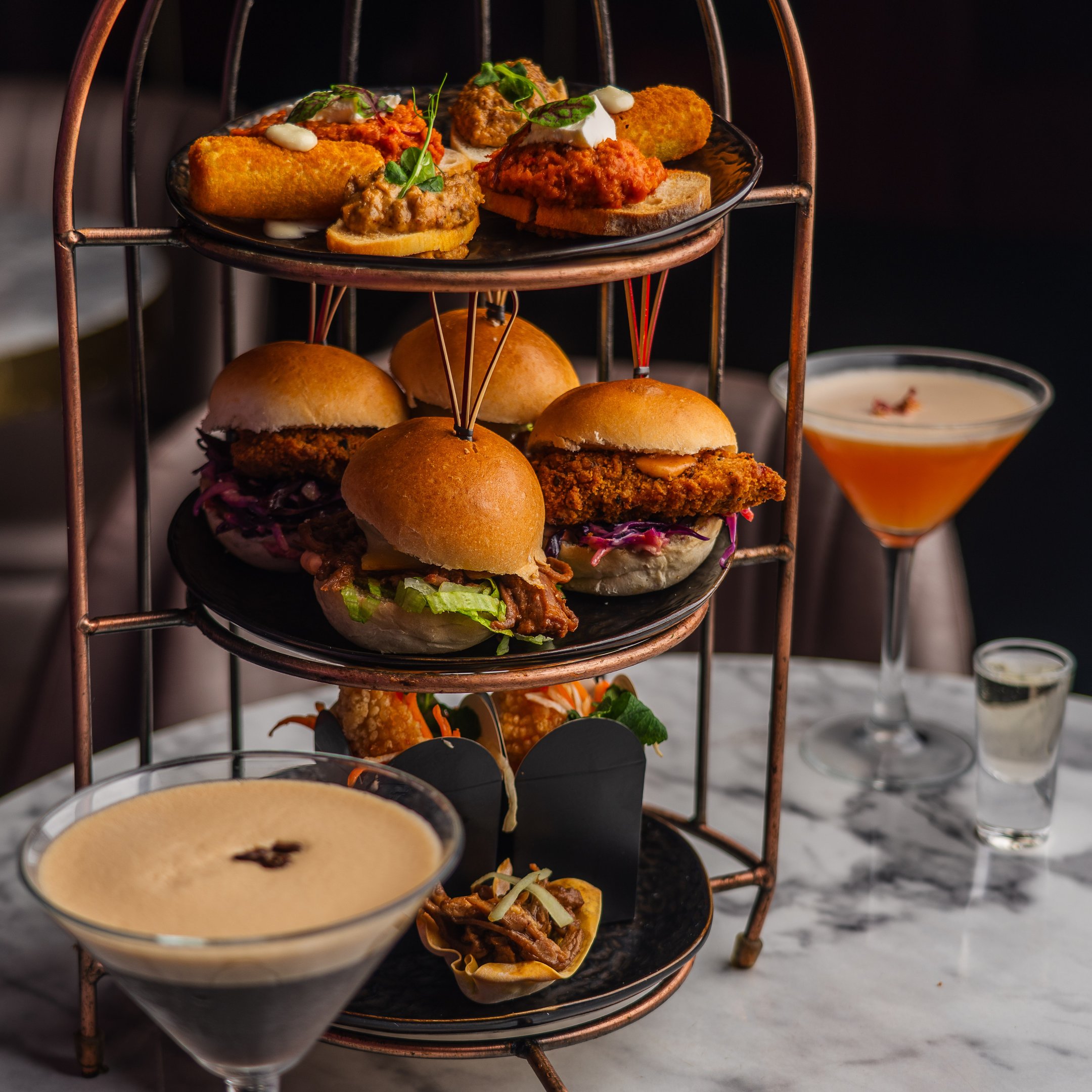 A birdcage food sharer with cocktails in Dirty Martini