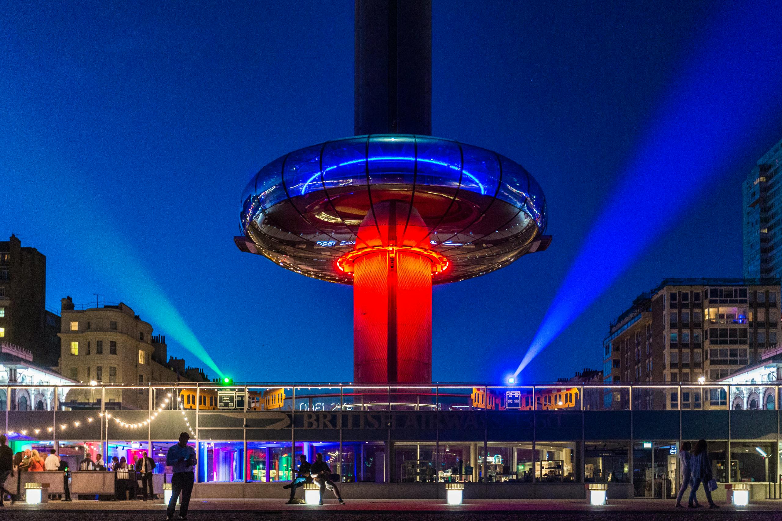 The Brighton i360 Pod lit up red in the evening