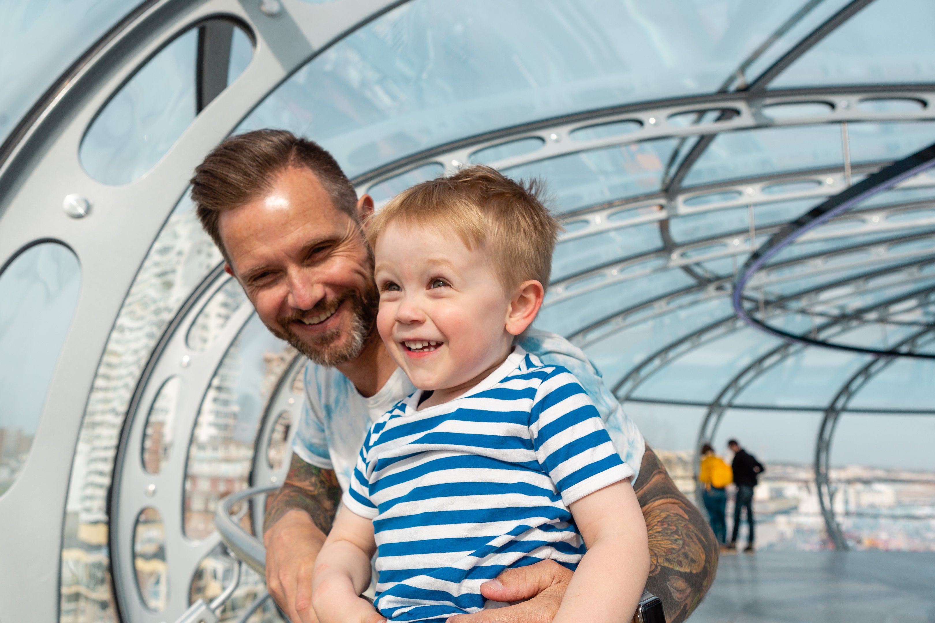 A parent and child enjoying the views in the Pod of the Brighton i360
