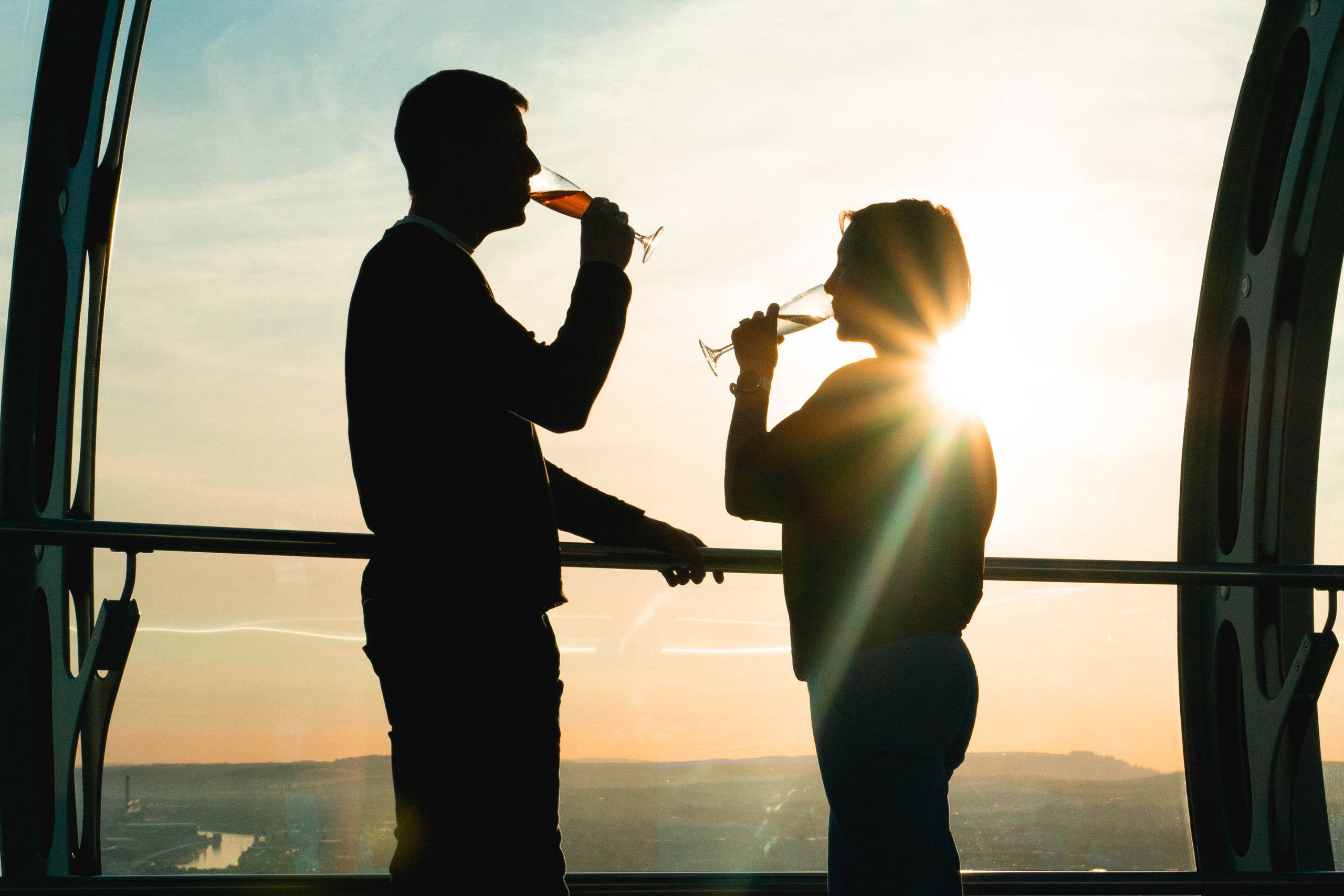 A couple drinking champagne looking out over Brighton from the i360 pod