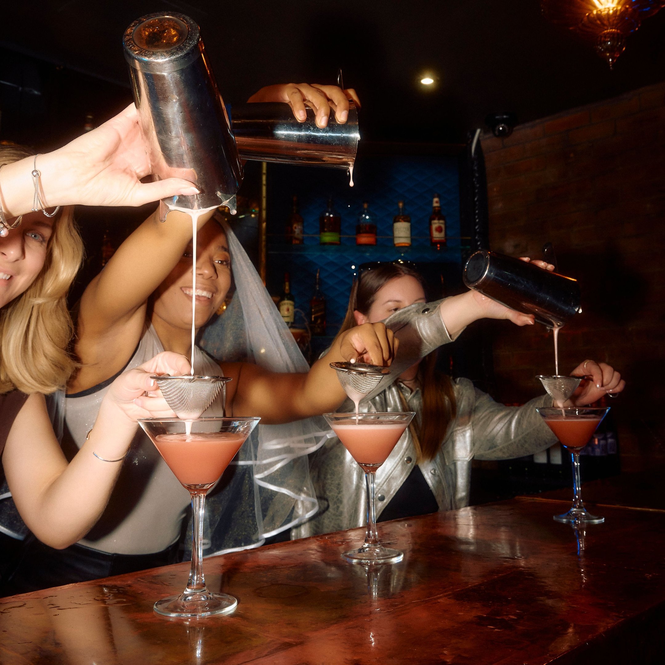 Bridal party pouring cocktails behind the bar in Dirty Martini