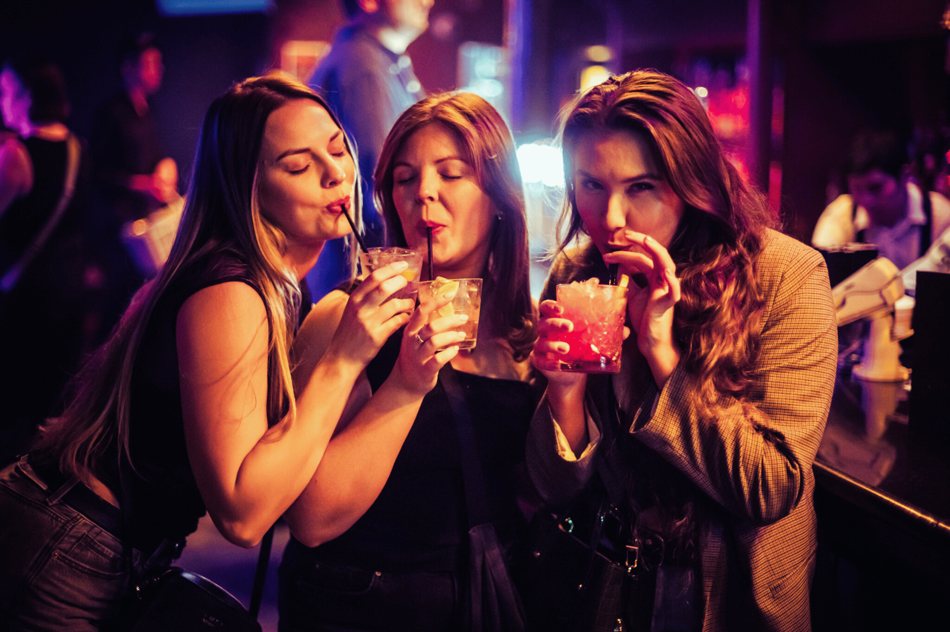 Three women sipping on drinks at the bar in The Piano Works