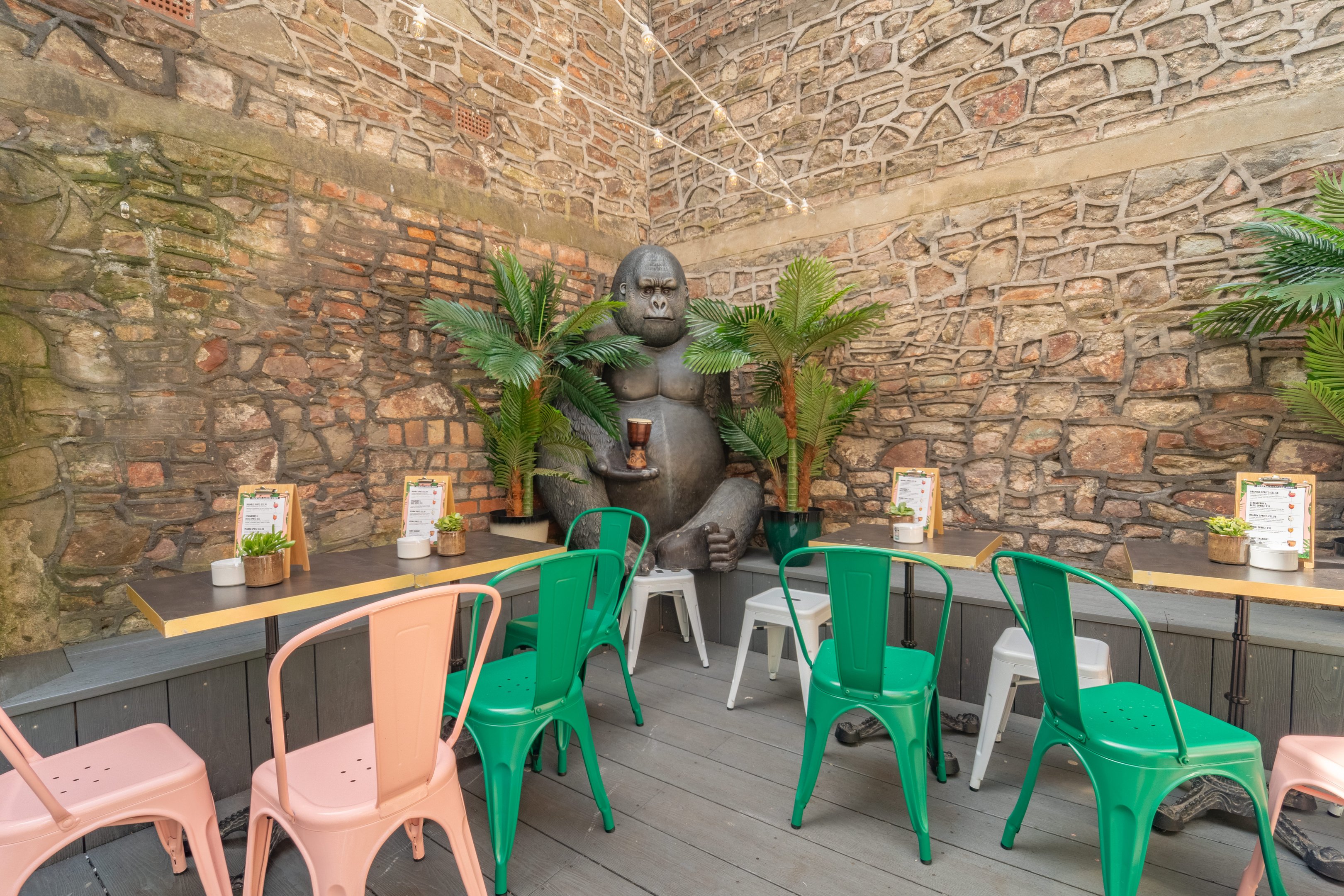 A corner of the outdoor terrace with a Gorilla statue and chairs and tables