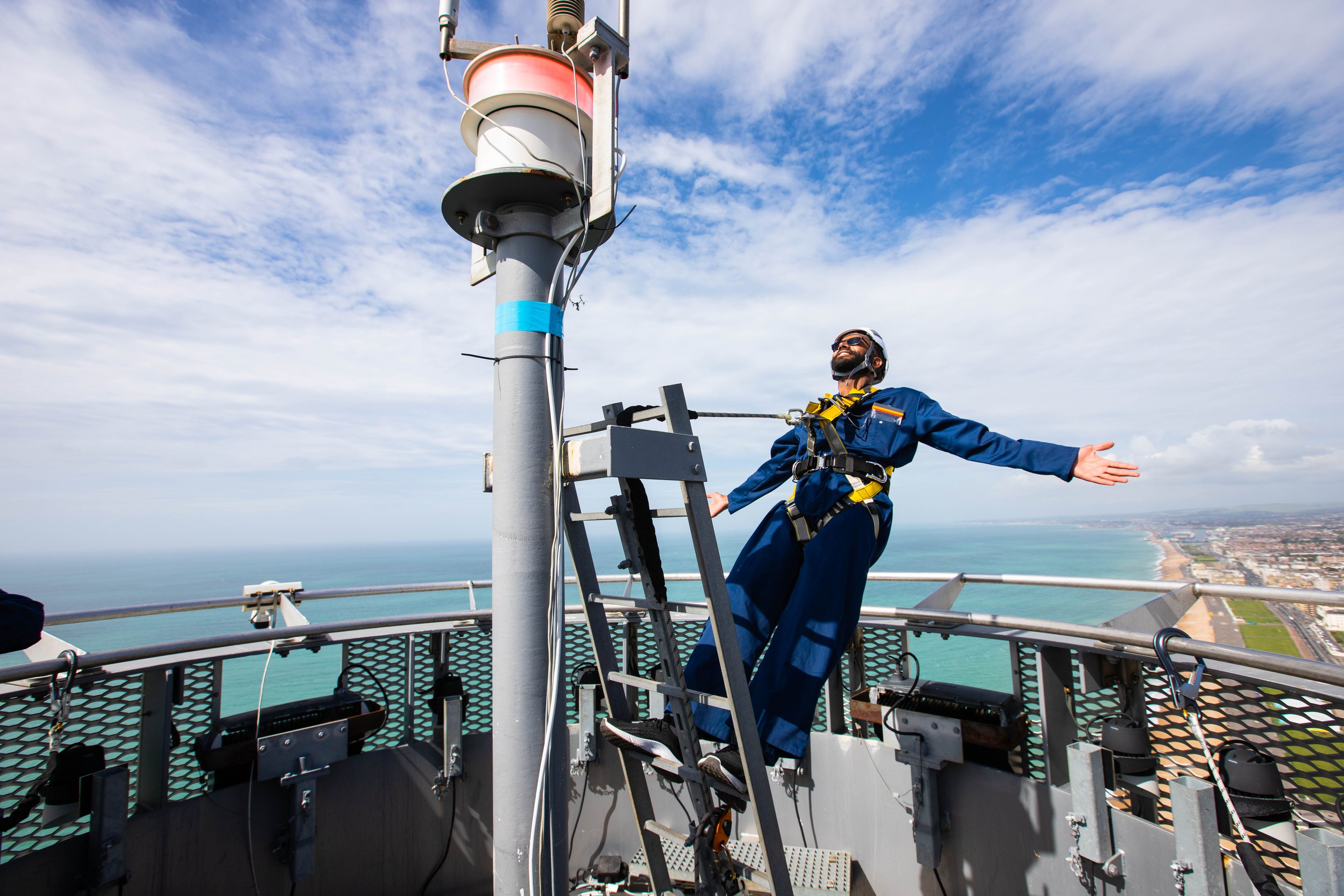 A guest leaning back whilst harnessed to the highest point of the Brighton i360