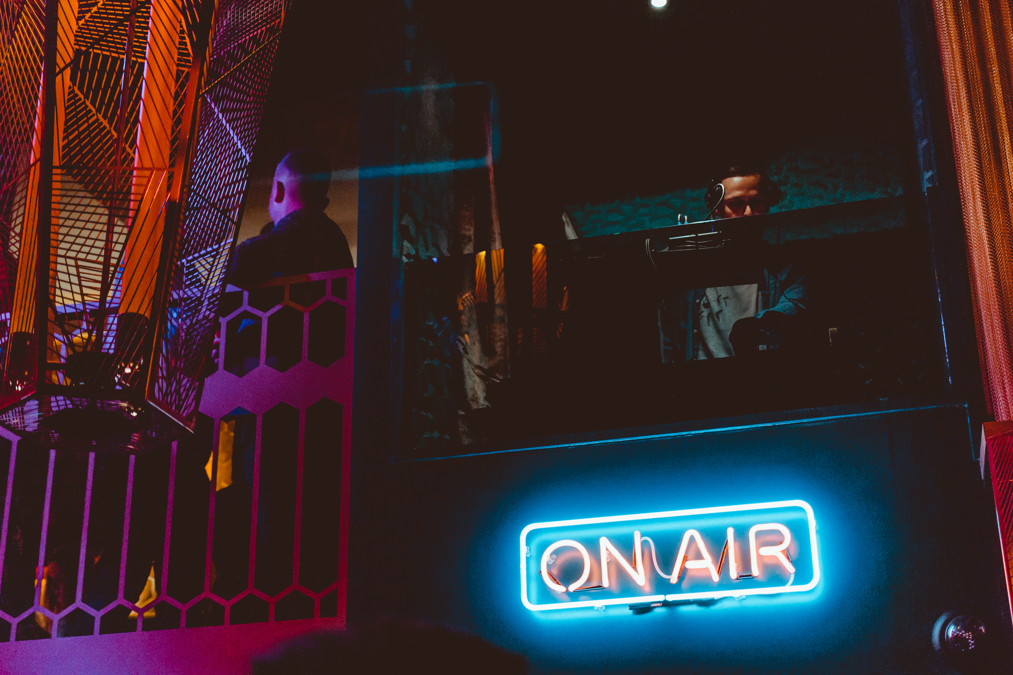 A DJ in a booth playing music in Dirty Martini